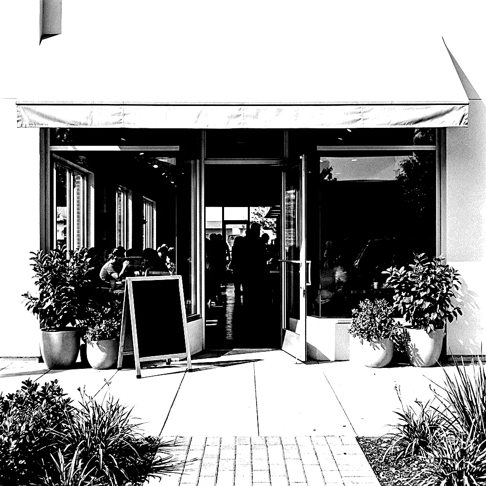 A photocopied black and white photograph of a busy small shopfront, full of customers.